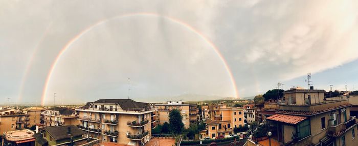 Panoramic view of rainbow over buildings in town