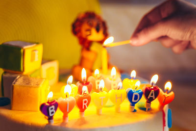 Close-up of hands lighting birthday candles on cake