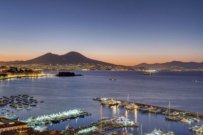 Sailboats in city at sunset