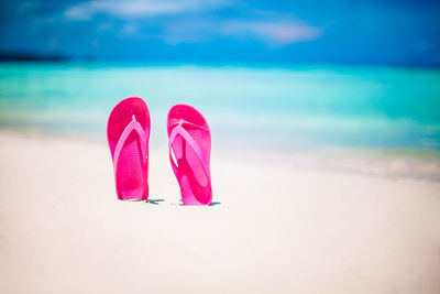 Pink umbrella on beach against sky