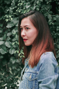 Portrait of beautiful woman standing against plants