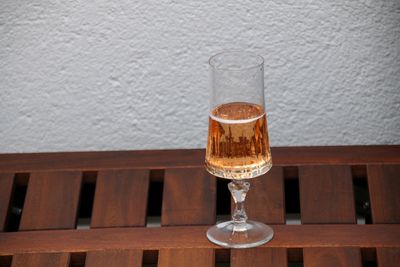 Close-up of wine glass on table against wall