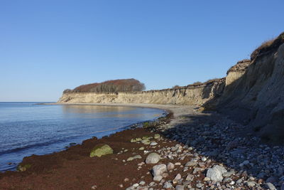 Scenic view of beach against clear blue sky