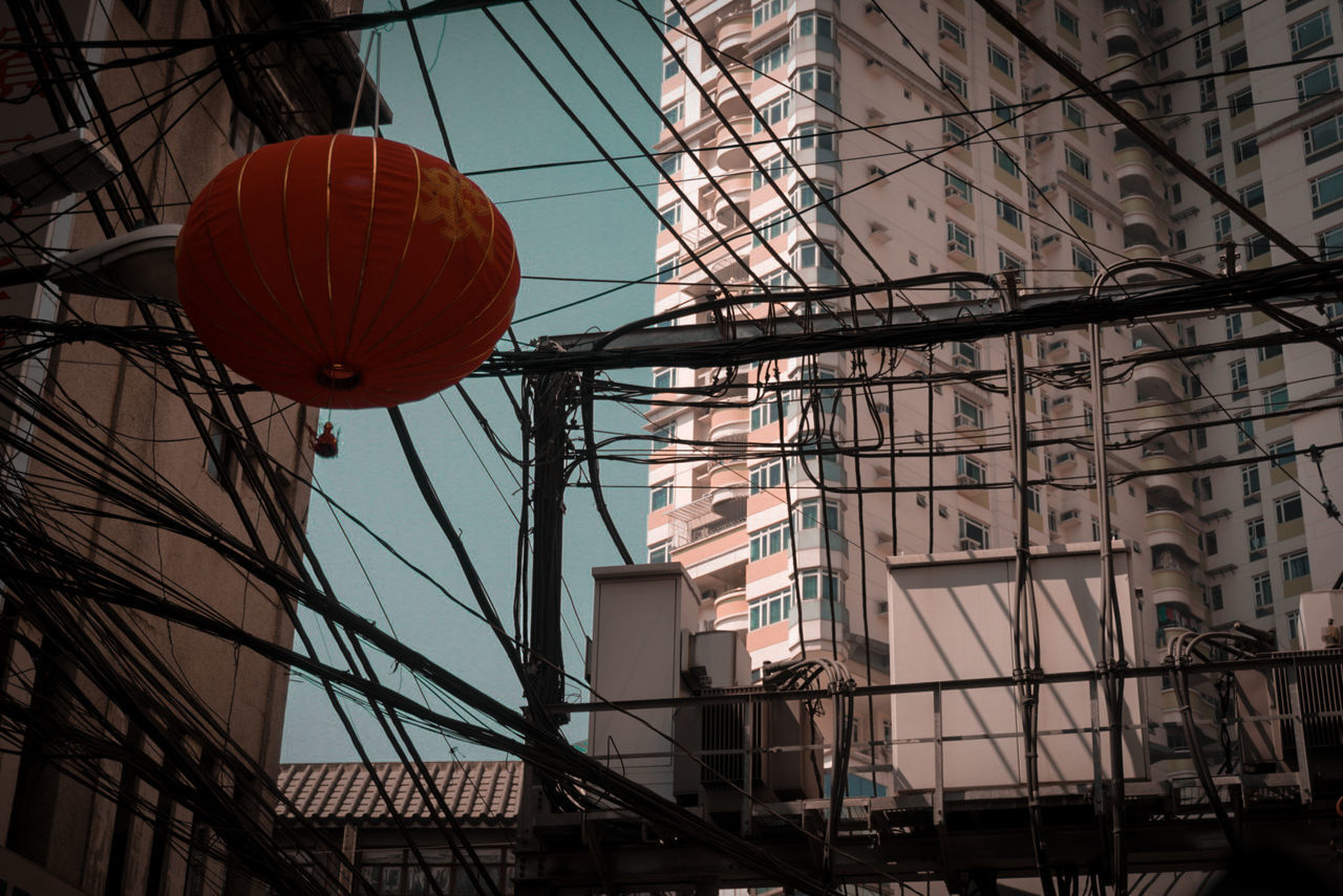 built structure, architecture, building exterior, low angle view, building, no people, lighting equipment, nature, day, city, outdoors, lantern, hanging, decoration, sky, residential district, window, red, cable, fuel and power generation, festival