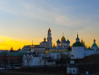 Buildings in city against sky during sunset