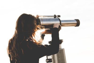 Woman looking through coin-operated binoculars