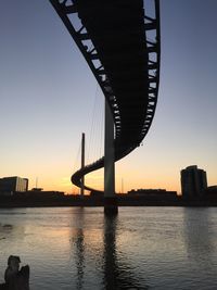 Footbridge over river during sunset