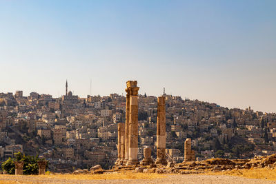 Buildings in city against clear sky