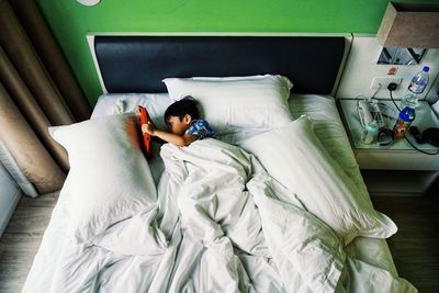 High angle view of boy resting on bed at home