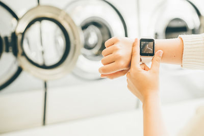 Close-up of woman checking time in laundromat