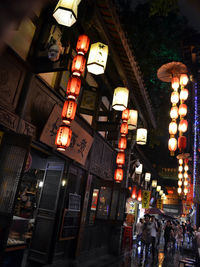 Low angle view of illuminated lanterns hanging on street at night