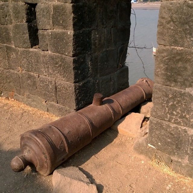 built structure, close-up, architecture, part of, wall - building feature, building exterior, outdoors, day, metal, textured, old, shadow, high angle view, street, sunlight, no people, weathered, pattern, stone material, sidewalk