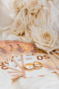 High angle view of currency and rings on table