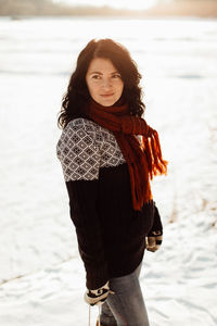 Woman in warm clothing standing on snow