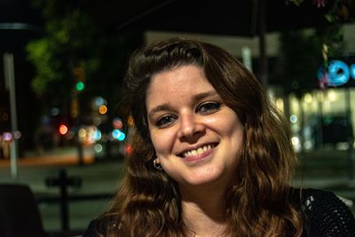 Portrait of smiling young woman at night