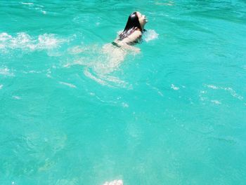 Woman in swimming pool against sea