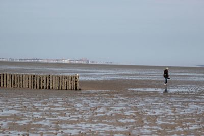 Man on beach against clear sky