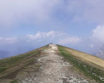 Low angle view of road leading towards mountain against sky