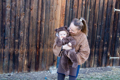 Portrait of smiling young woman holding baby in her hands. mother and son. kid watching at camera