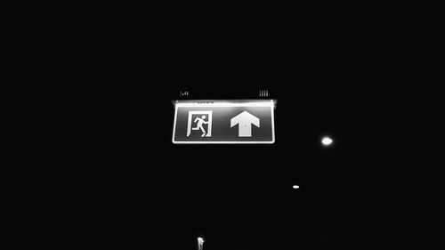 Low angle view of illuminated sign at night