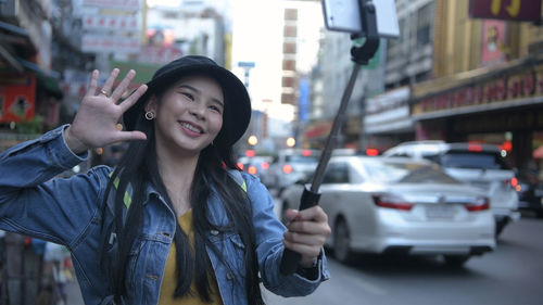 Young woman standing on street in city