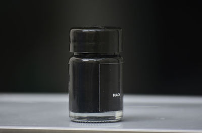 Close-up of bottle on table against black background