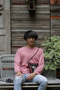 Full length of a young man sitting on seat