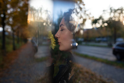 Young woman on road amidst trees