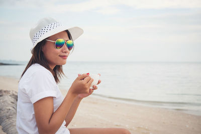 Woman having coffee at beach 