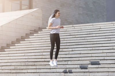 Full length of woman on staircase in city