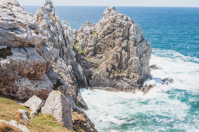 Scenic view of rocks in sea against sky