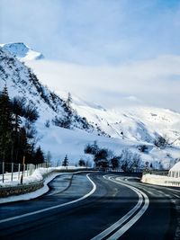 Scenic view of mountain road against snowcapped mountains