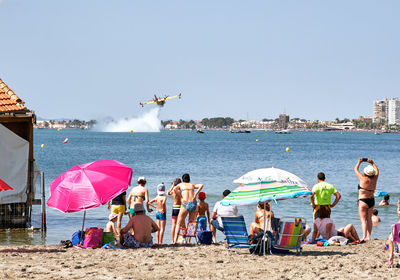 People on beach against clear sky