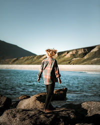 Rear view of woman standing at beach
