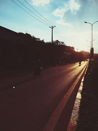 Cars on street in city against sky