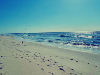 Scenic view of beach against clear blue sky