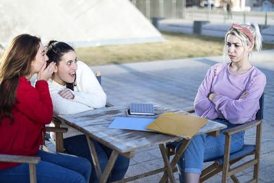 Young woman sitting on table at restaurant