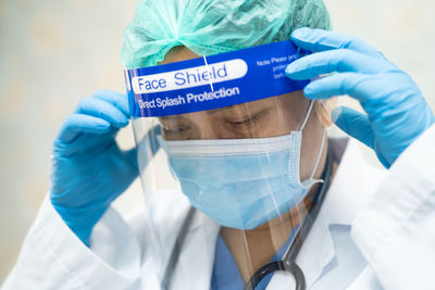 Close-up of doctor wearing surgical mask and face shield at hospital