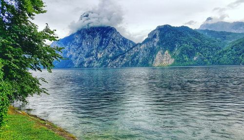 Scenic view of lake by mountains against sky