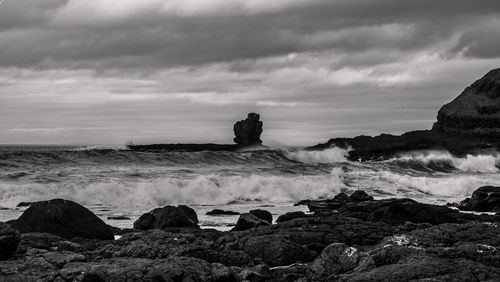 Scenic view of rocks on beach against sky