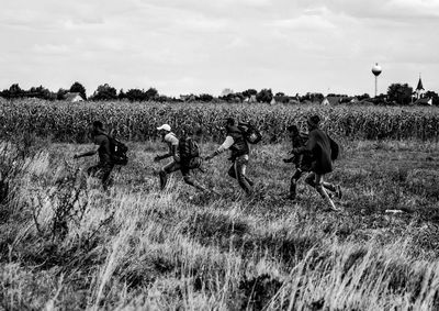 Refugees running on field