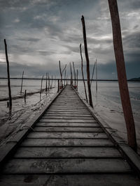 Wooden pier over sea against sky