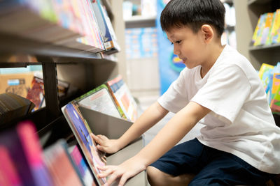 Side view of boy looking at book
