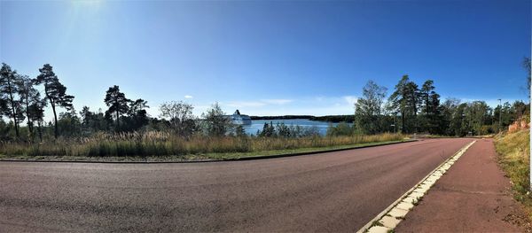 Empty road against clear blue sky