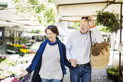 Happy senior couple walking at flower market