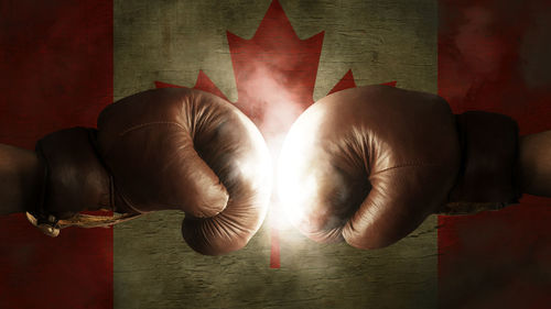 Close-up of boxing gloves in front of canadian flag
