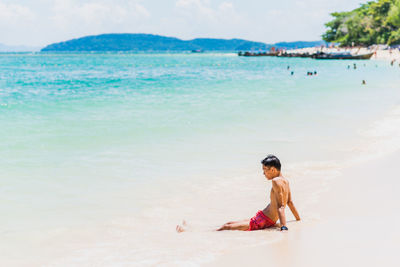 Full length of man relaxing on beach