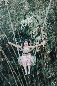 Young pretty asian woman is swinging on the cliff of the jungle in ubud, bali.