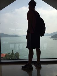 Full length of man standing by lake against sky