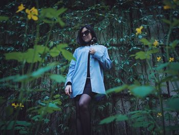 Low angle portrait of sensuous woman standing against wall at park